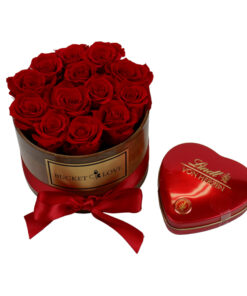 red lindt heart with chocolates besides wooden bucket of love with res roses