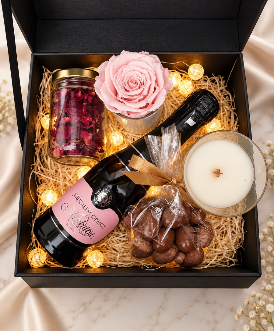 Gift box with a rose, sparkling wine, a candle and chocolates